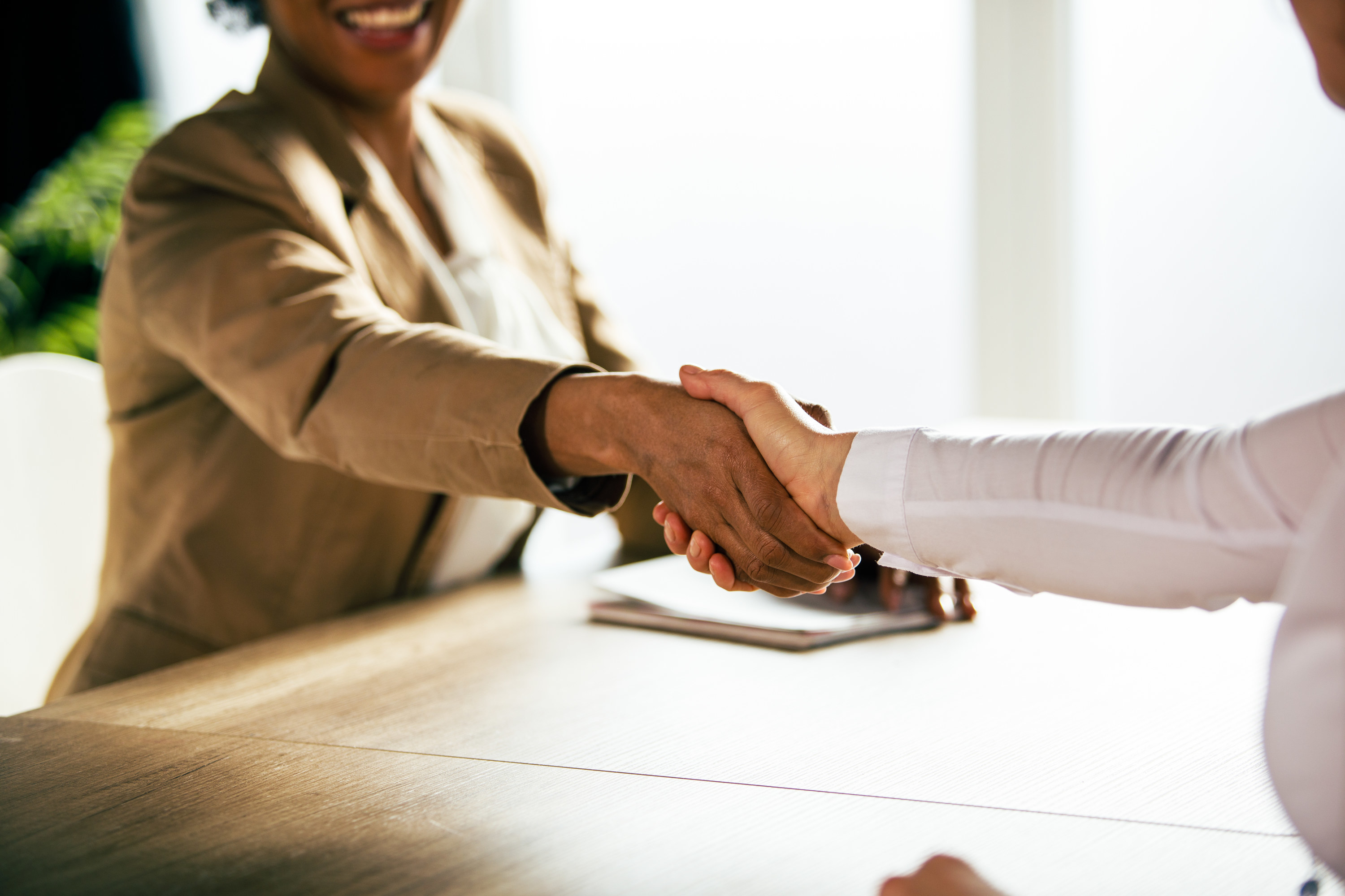 Women shaking hands over a table