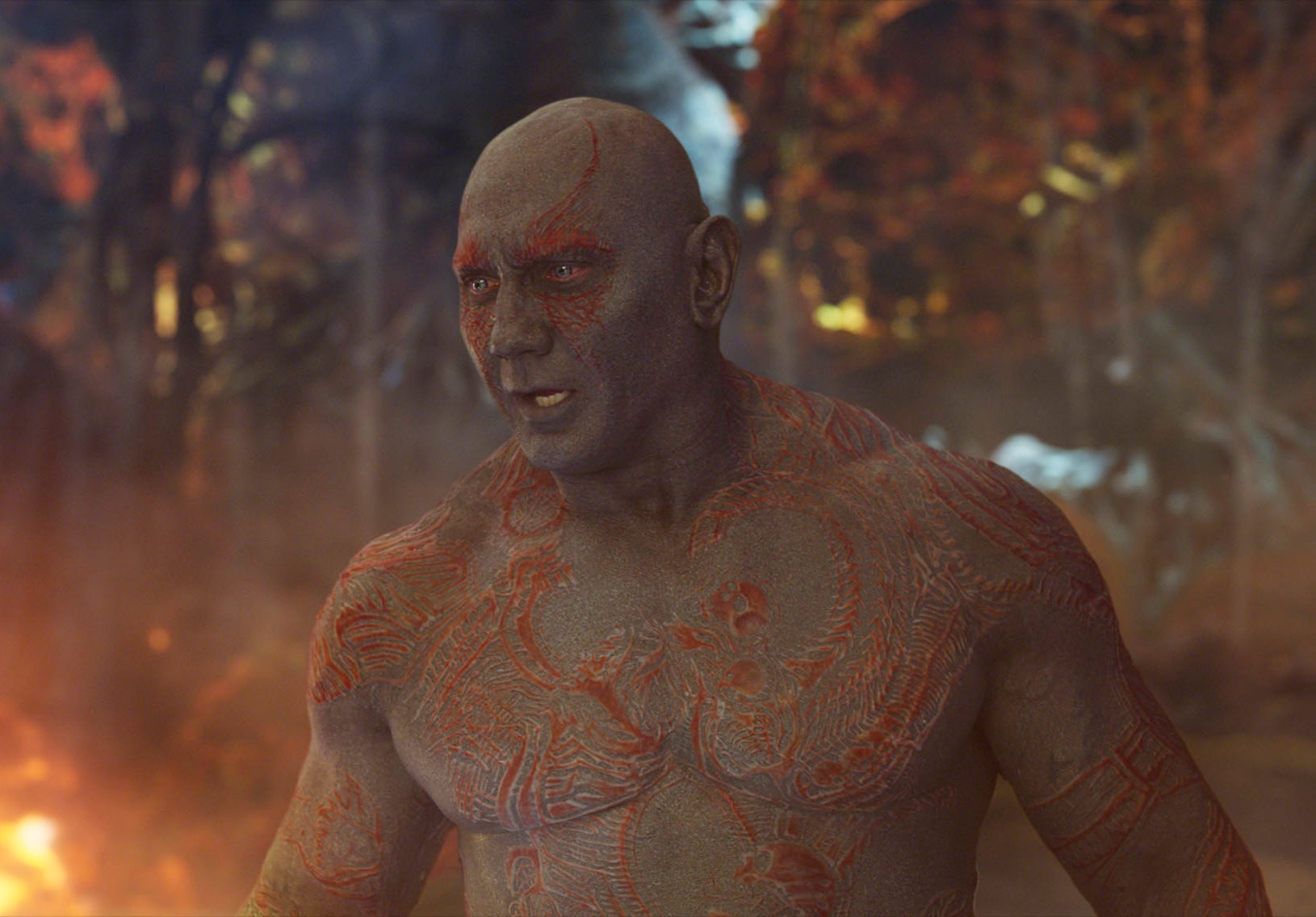 Drax stands in front of a fiery scene