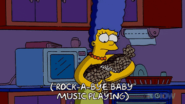 marge simpson rocking a bag of potatoes while the song plays in the background