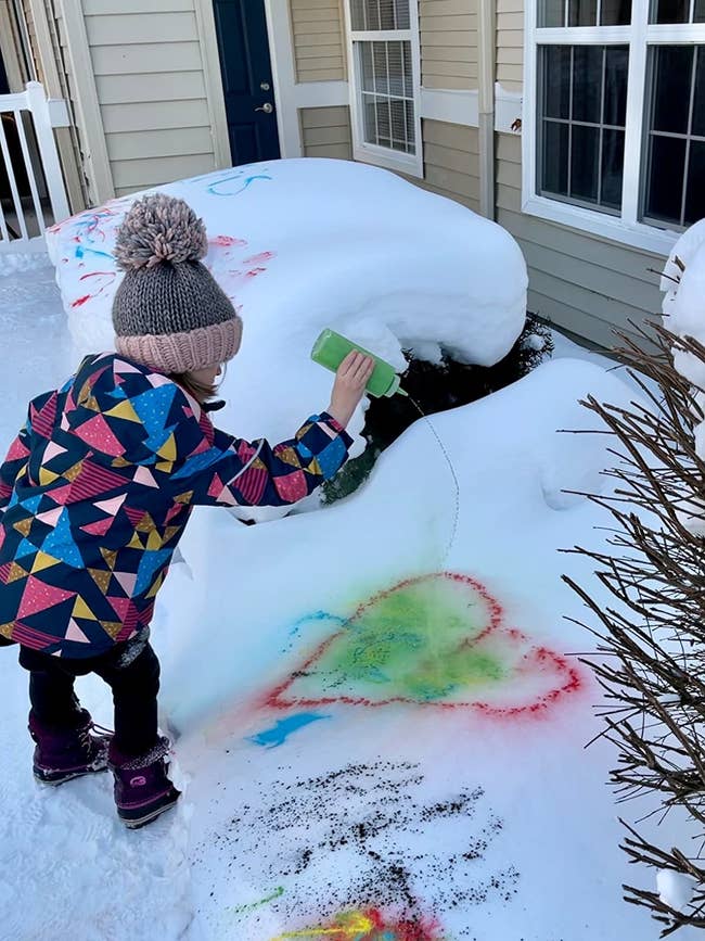 reviewer's photo of a child spray painting a heart in the snow