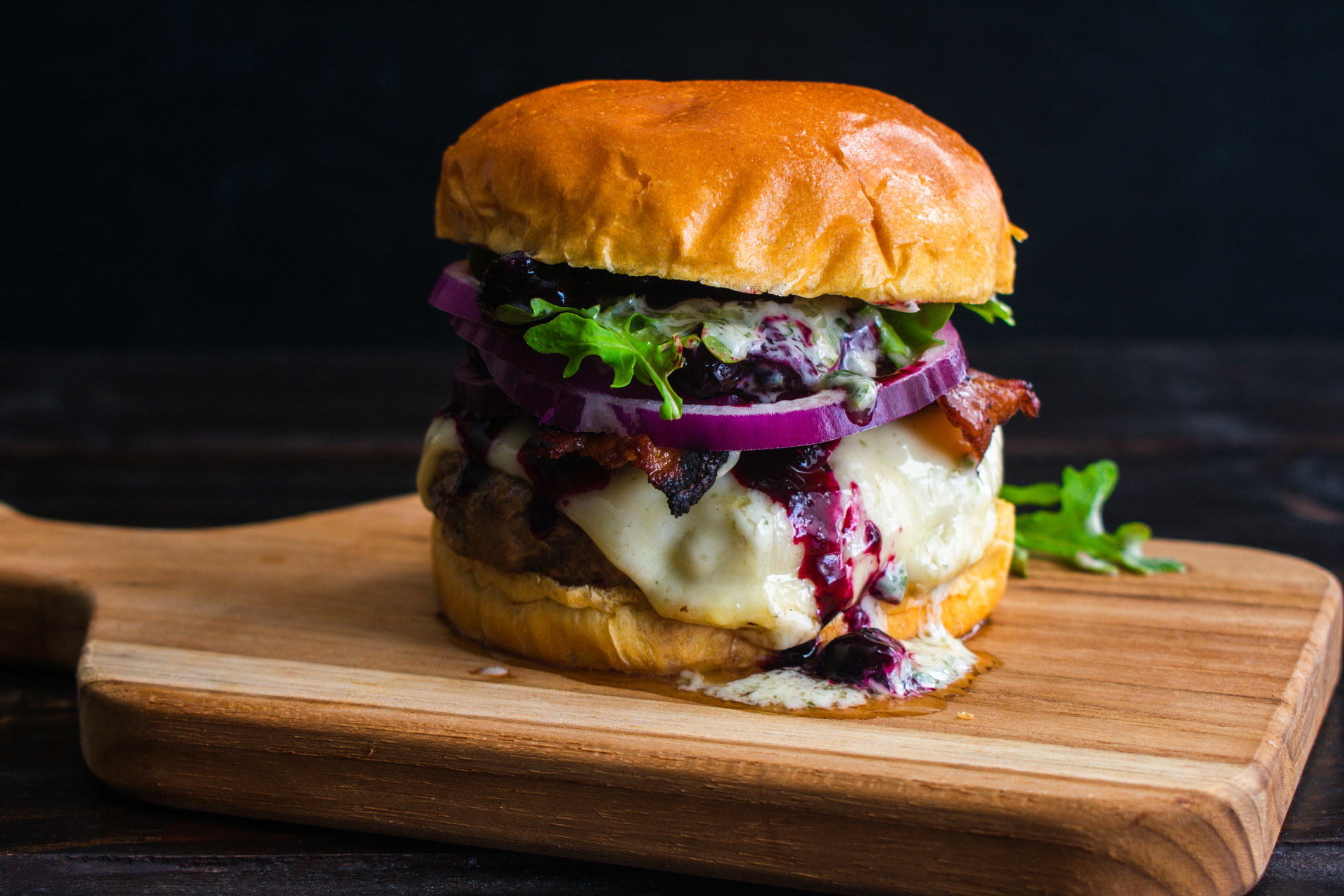 A thick cheeseburger on brioche with red onion