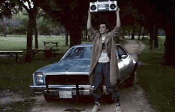 John Cusack holding a boombox next to a car