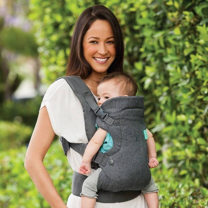 a person with a baby in the baby carrier