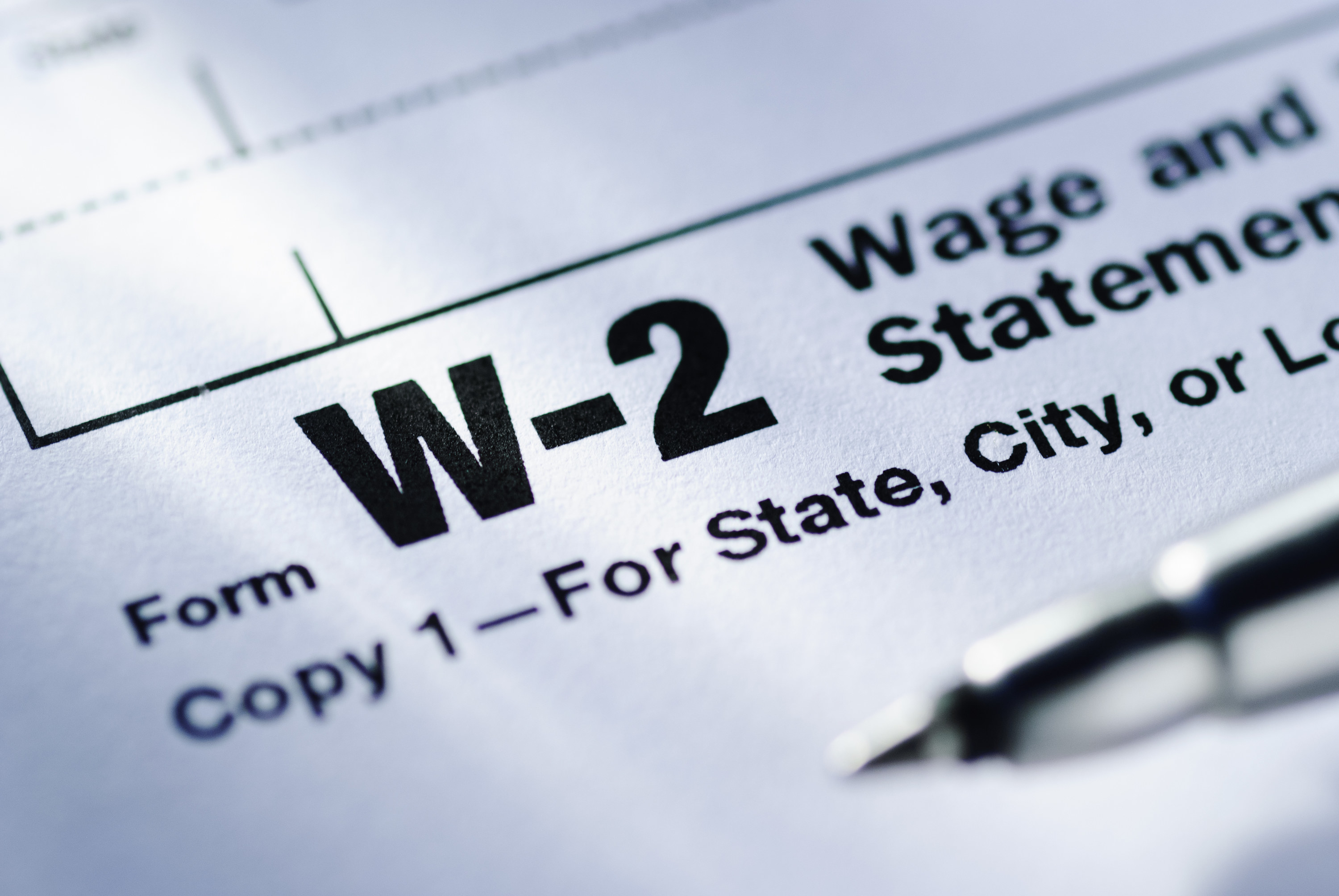 Pen on a Form W-2 Wage and Tax Statement for the US Treasury to be submitted by the employer in close up in a conceptual financial image