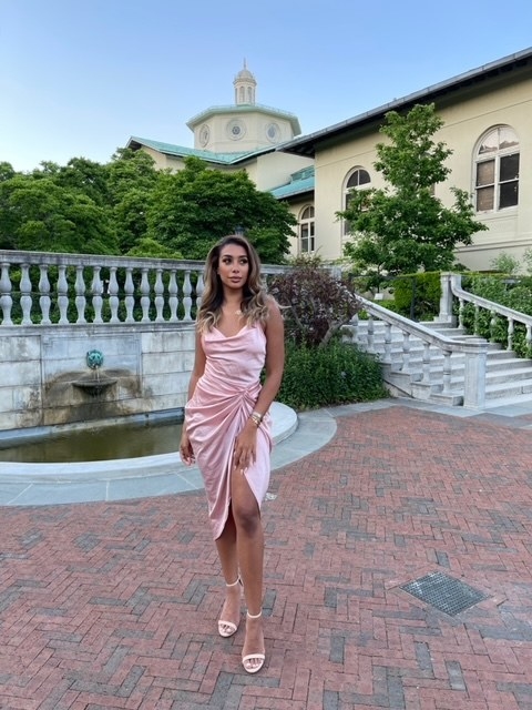 Sahar in a pink dress in front of a fountain