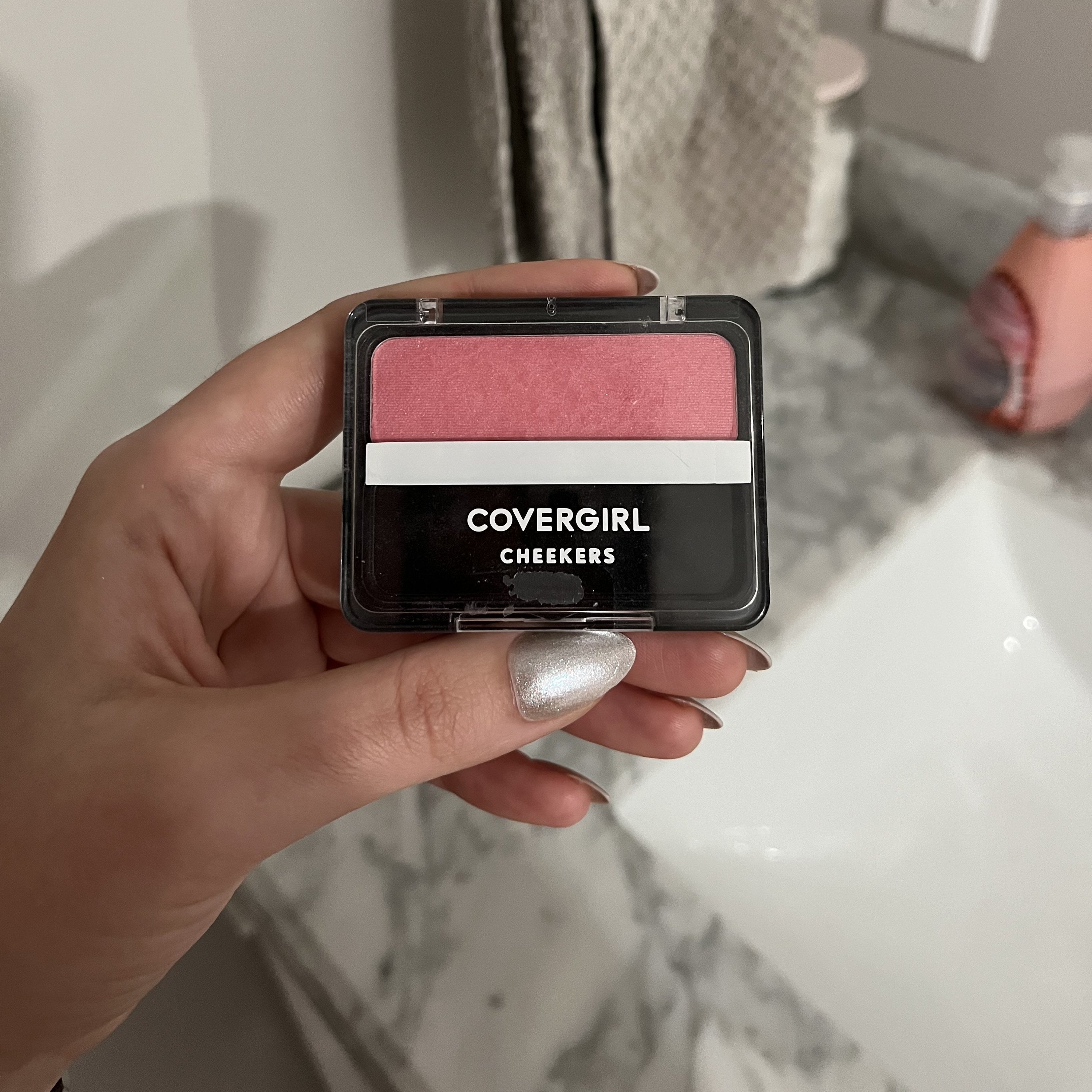 Melina holding the covergirl blush