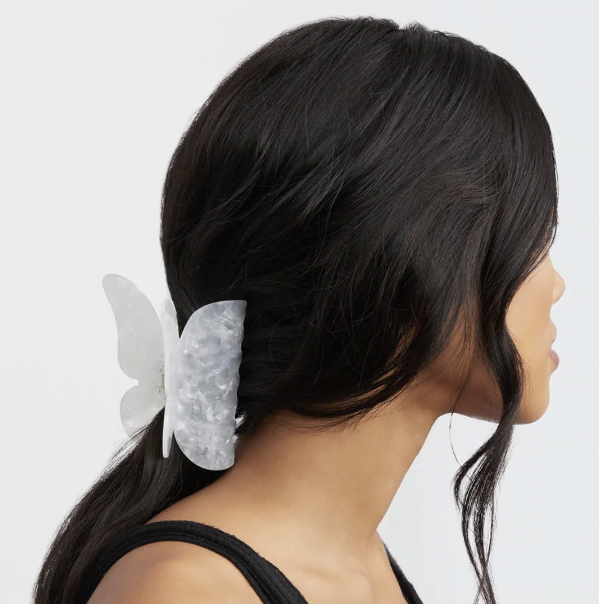 the butterfly-shaped hair clip holding a person's mane back