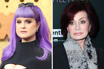 Kelly Osbourne wears a black top with a cutout across the chest and purple hair with a black bow. Sharon Osbourne wears a black blazer over a gray top with black swooshed designs.