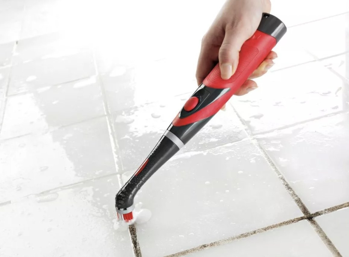 The scrubber cleaning away dirt in tile grout