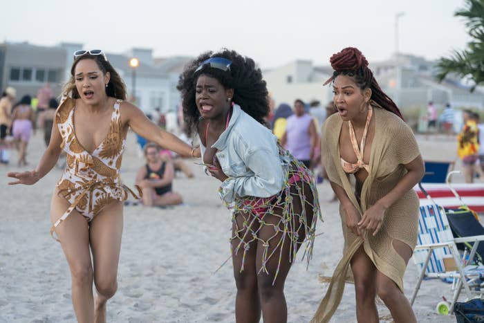The ladies of Harlem looking shocked as they stand on a beach