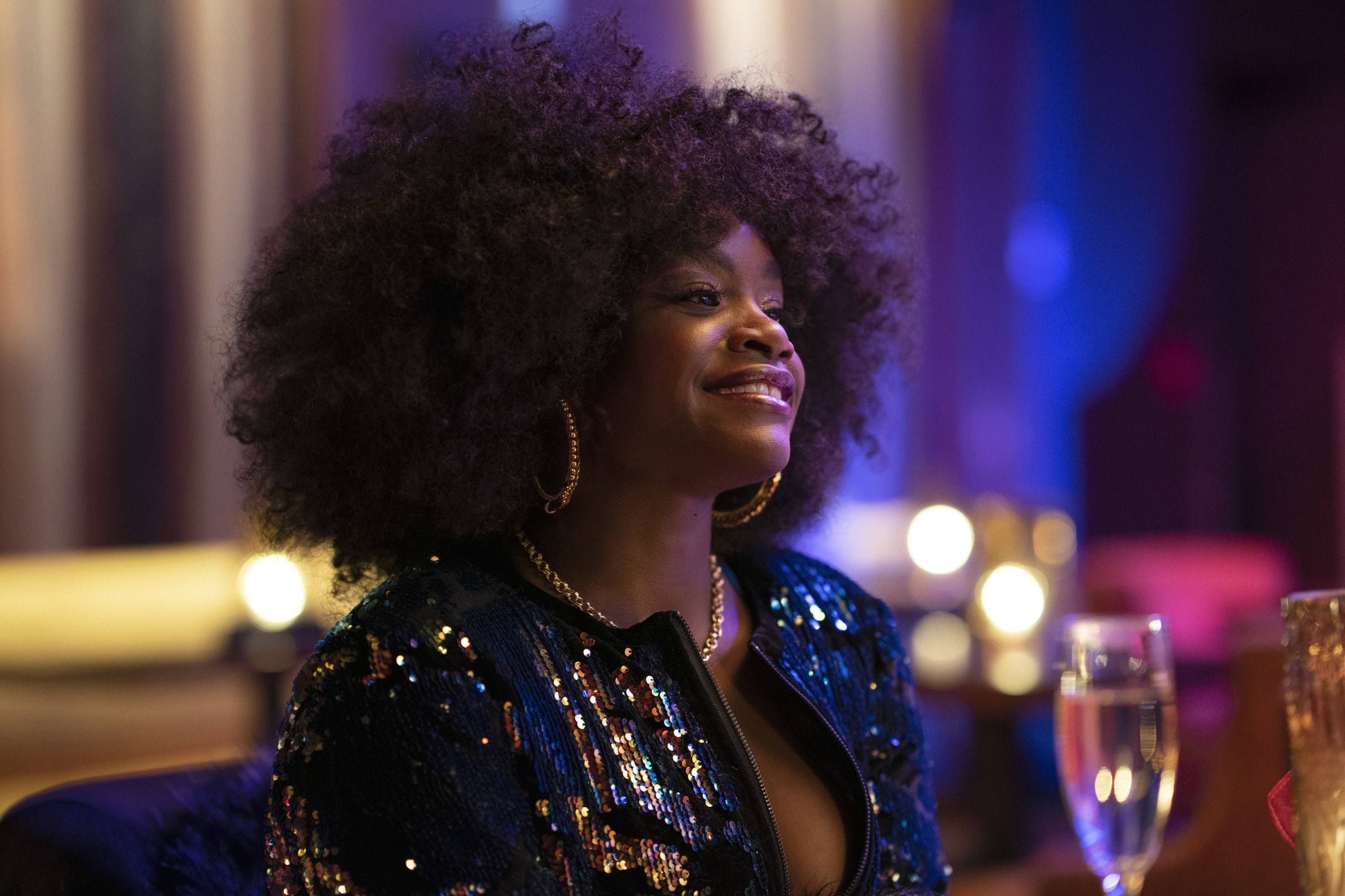 Angie sitting at a table with a glass of bubbly