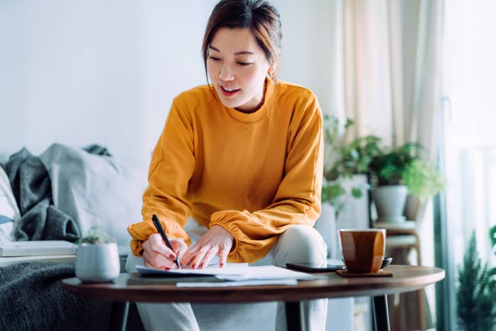 a woman writing on a piece of paper