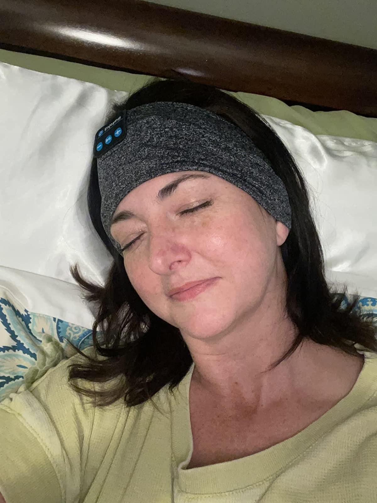 a reviewer with the headband on while lounging in bed