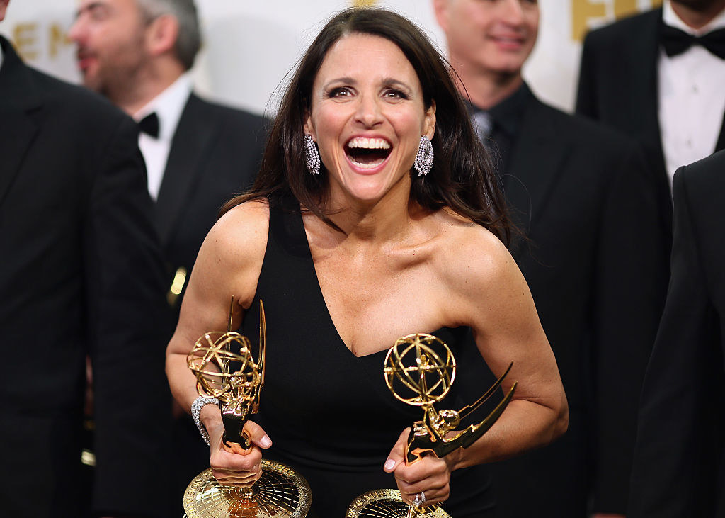 Julia holding two Emmy awards as she smiles widely
