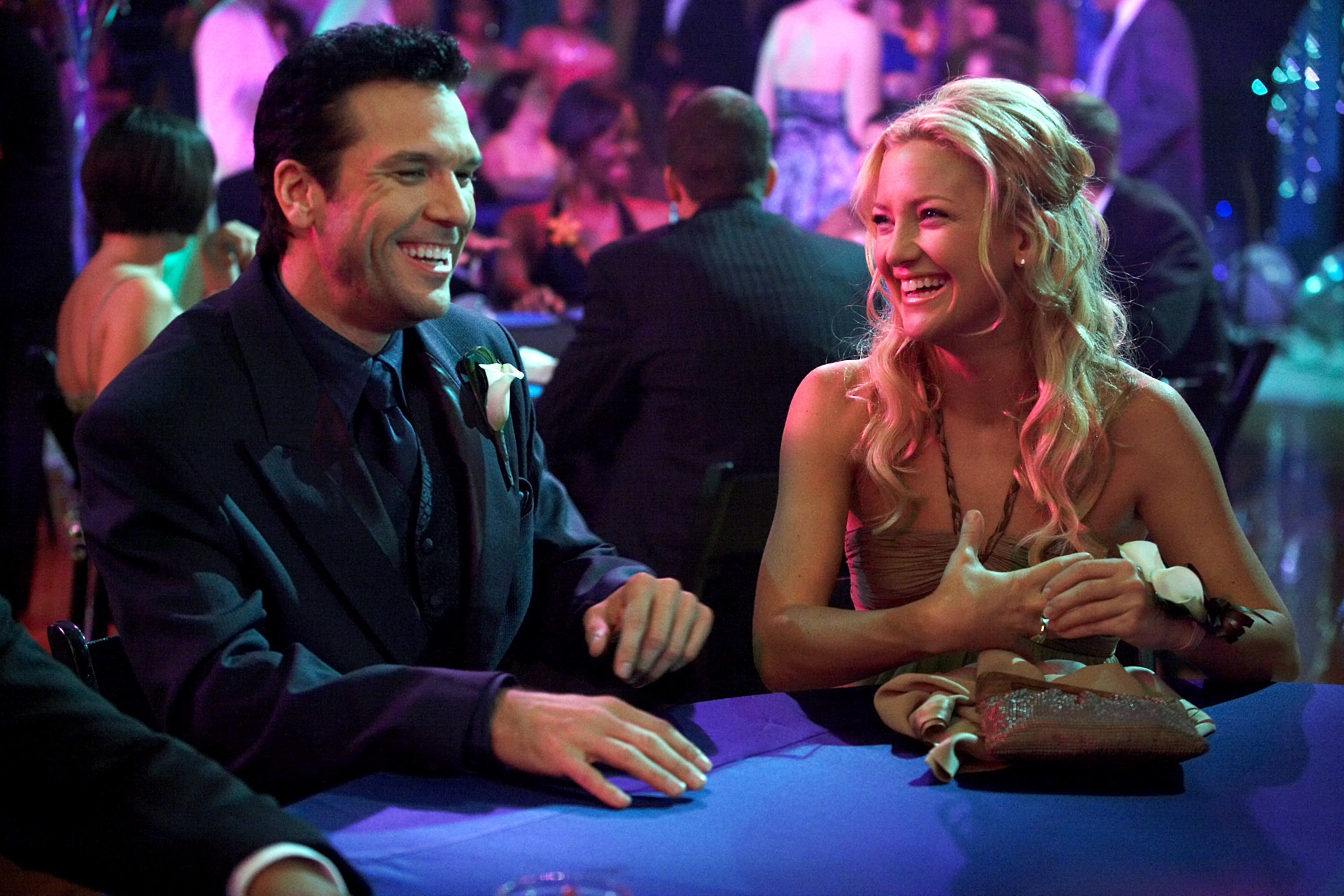 Kate and Dane smile while sitting at a table in My Best Friend’s Girl