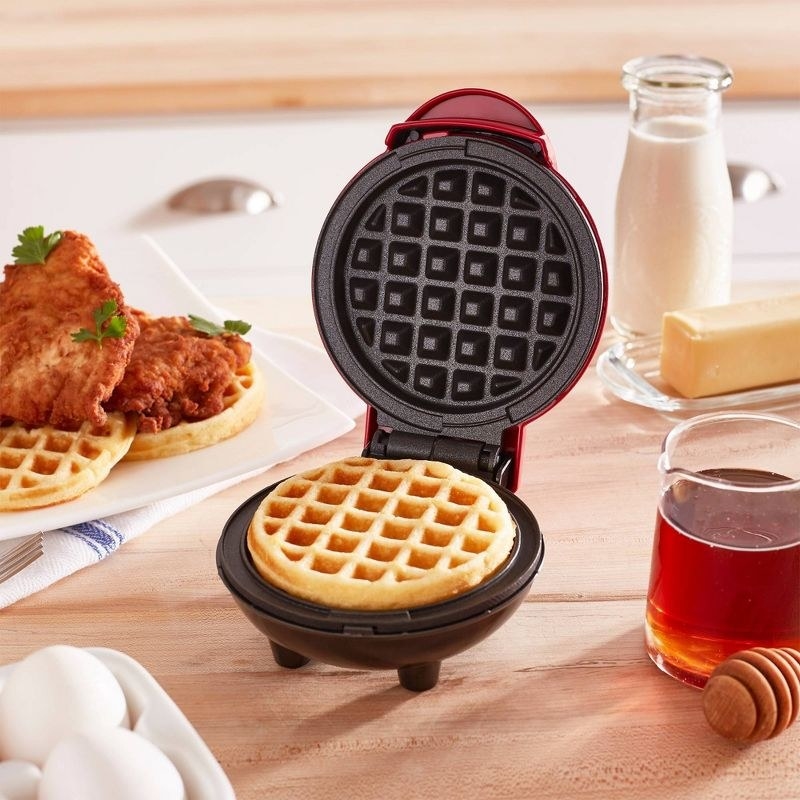the red waffle maker on a countertop