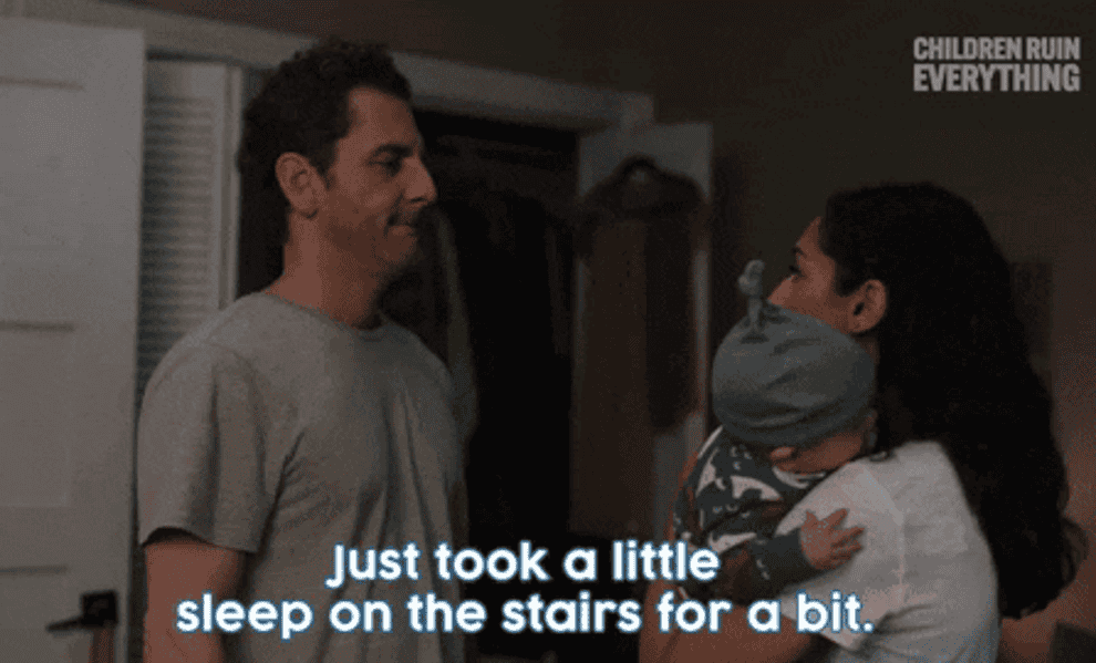 mom holding a baby while the dad says, just took a little sleep on the stairs for a bit