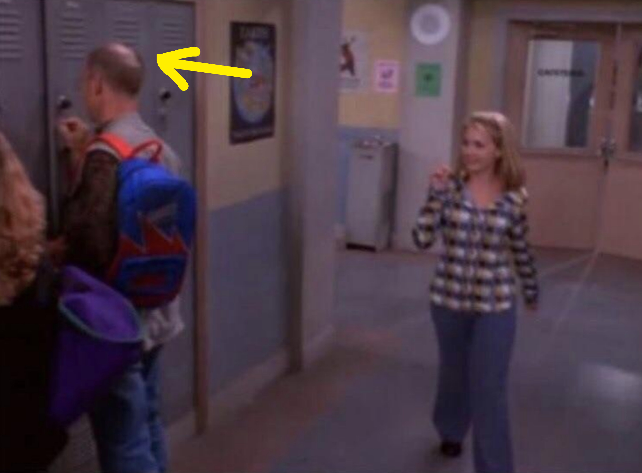 arrow pointing to the balding head of the extra playing a high schooler