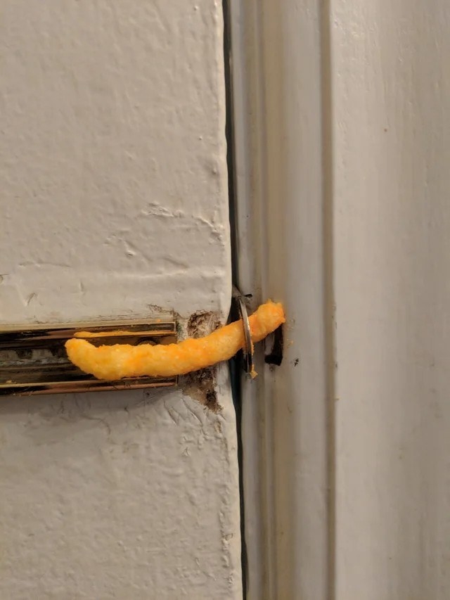 a door latch being held shut with a crunchy cheeto