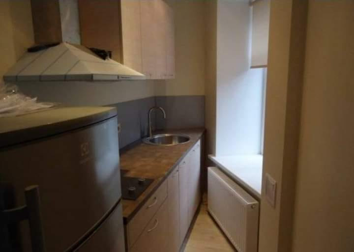 a horribly designed kitchen shaped like a triangle with an inaccessible sink