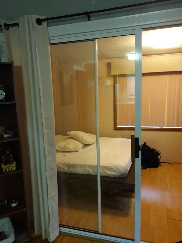 a bedroom with a sliding glass door and a shower curtain for privacy