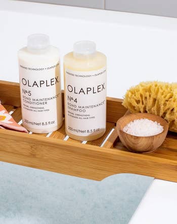 Olaplex shampoo and conditioner bottles sitting in a wooden tray