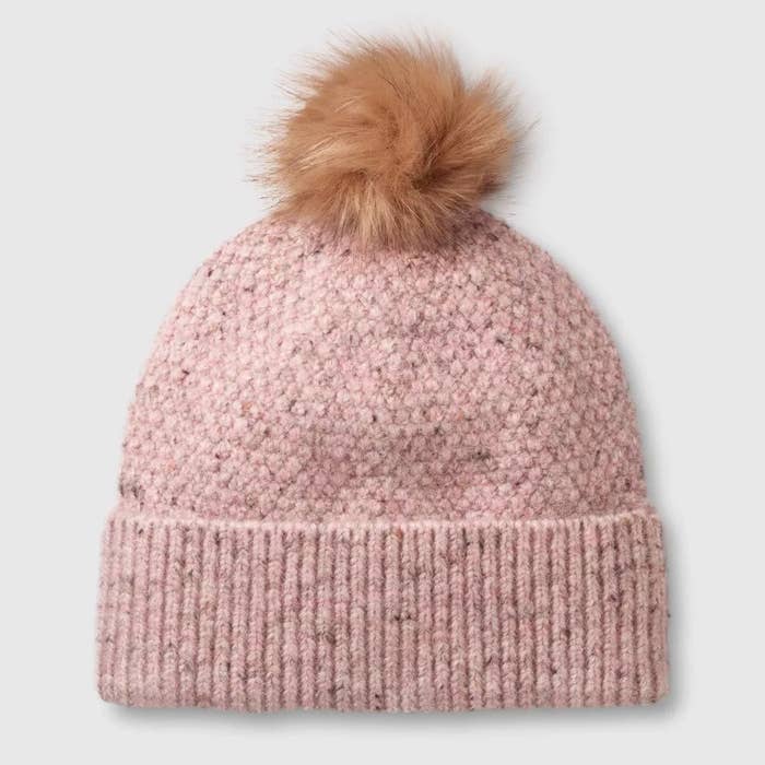 the pink beanie with a brown pom-pom on top