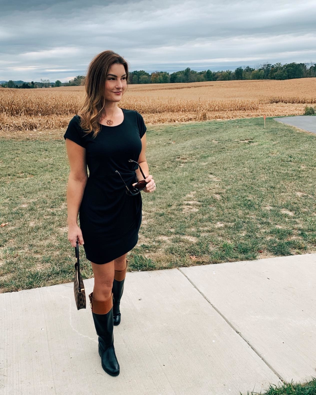 A reviewer wearing a black dress with black and tan shoes