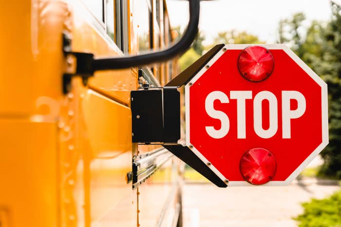 stop sign extended on a yellow school bus