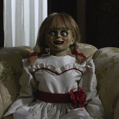 A bloody Annabelle sitting on a sofa