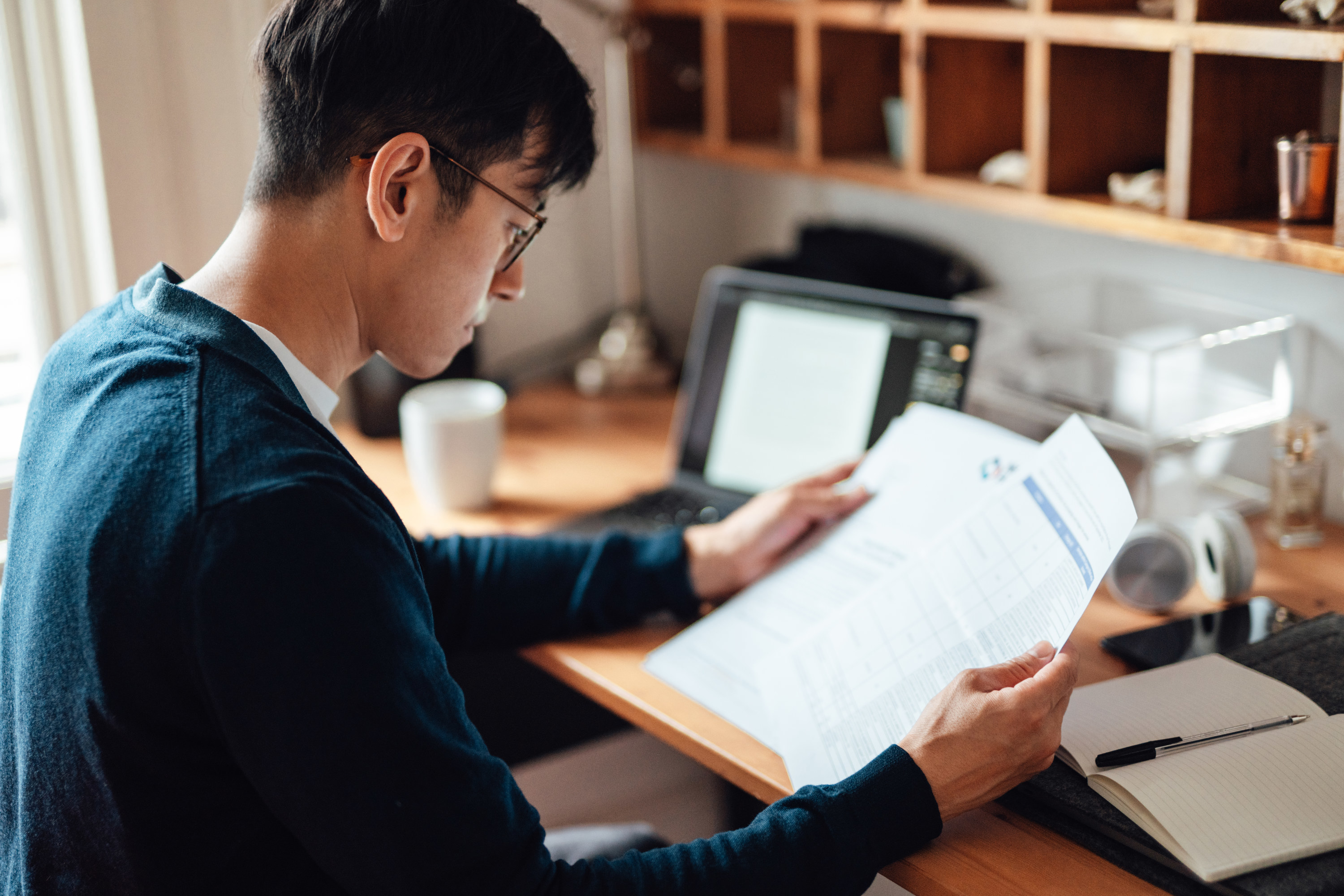 man looking at various bills on paper