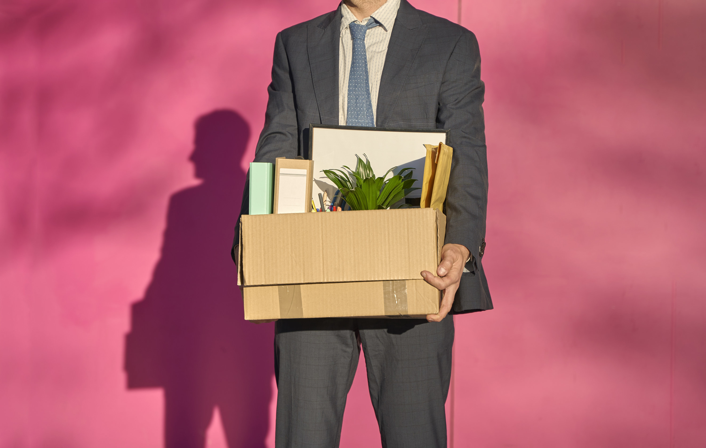 man leaving an office with a box after getting laid off