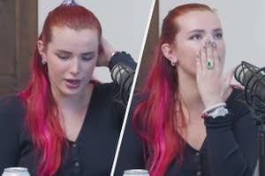 Bella Thorne wears a black cardigan and a silver watch with red hair with pink highlights.