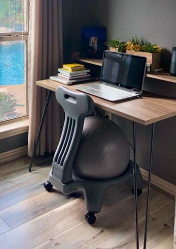 the gray exercise ball chair in a reviewer's desk setup