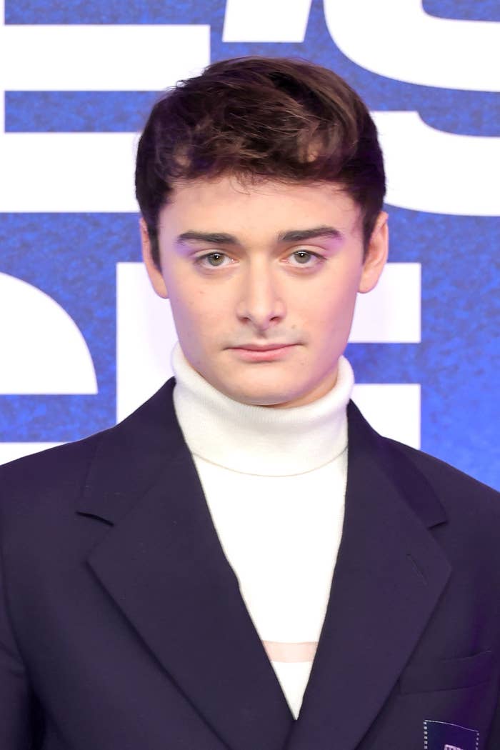 A close-up of Noah at a red carpet event wearing a suit and a turtleneck