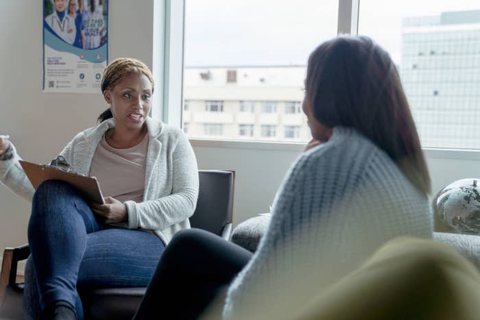 A woman sits on the sofa of her therapist's office as she shares about her depression and seeks help.