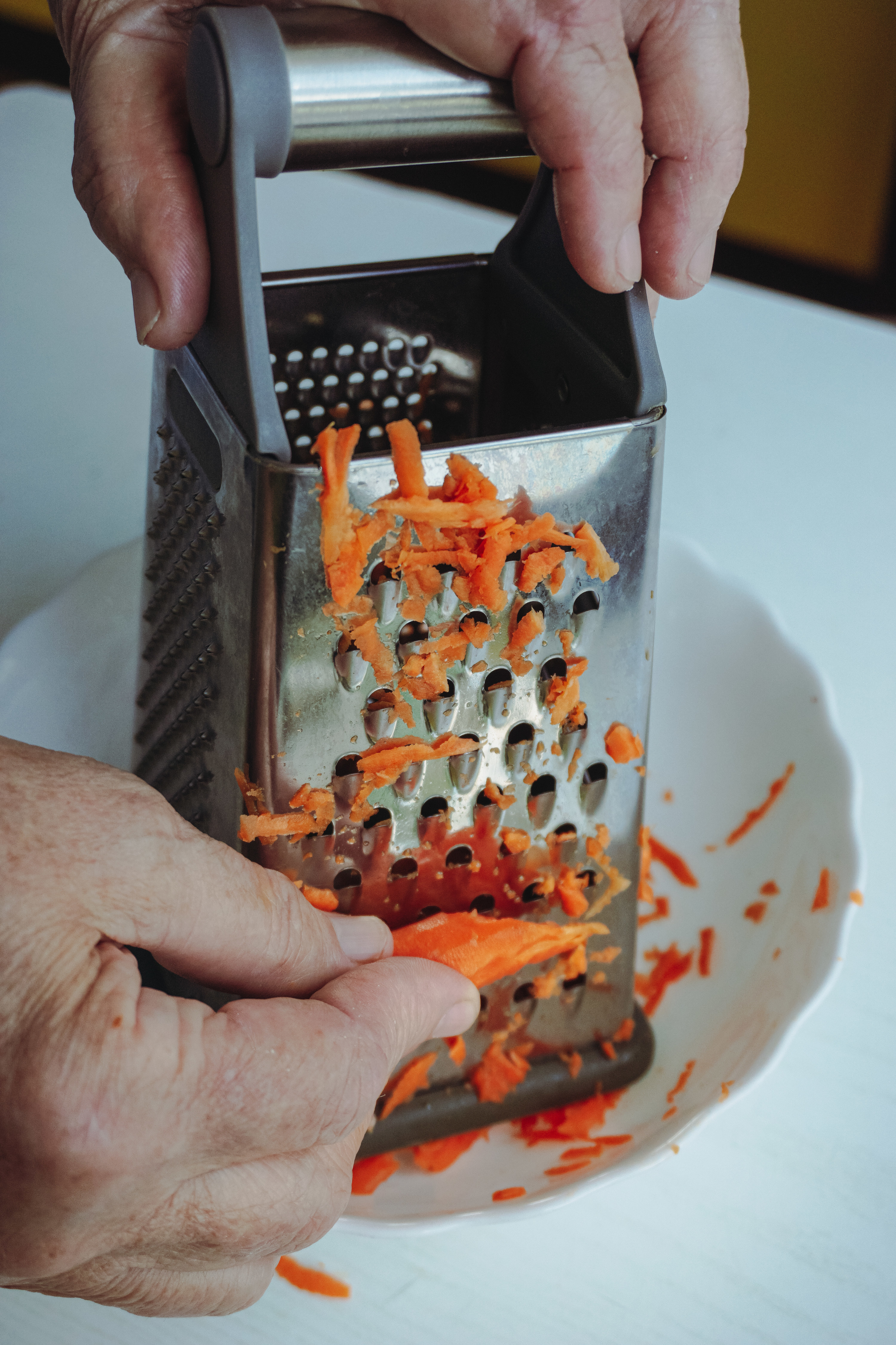 grated carrots with a box grater into a bowl