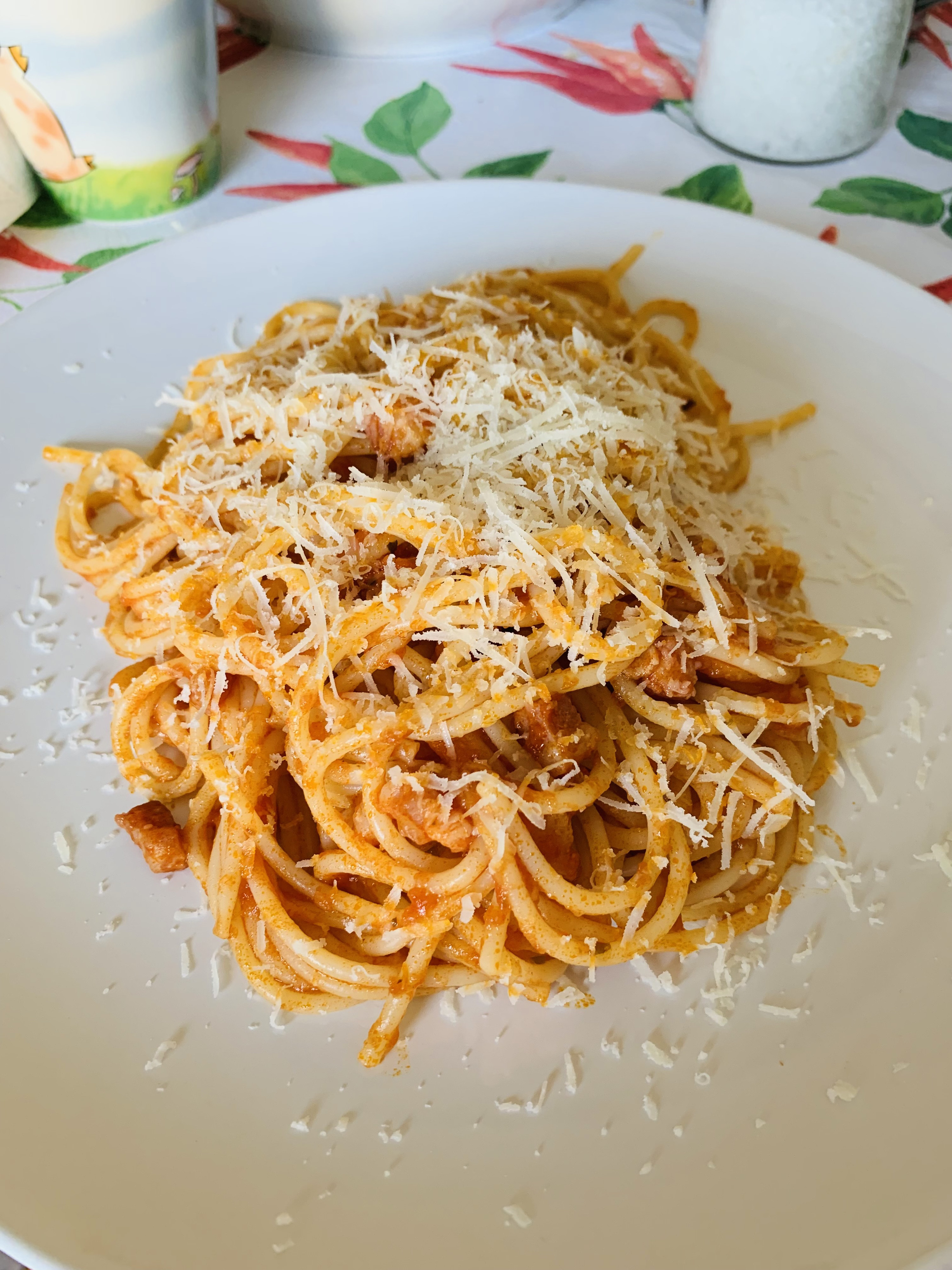 spaghetti on a plate with parmesan cheese and a tomato sauce