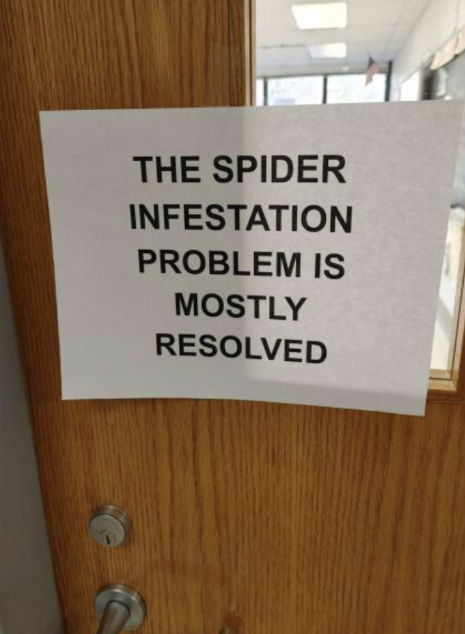 Door sign saying &quot;The spider infestation problem is mostly resolved&quot;