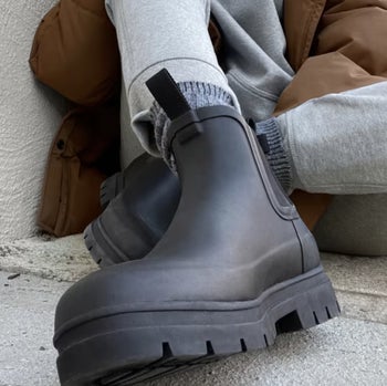 model wearing he black rain boots