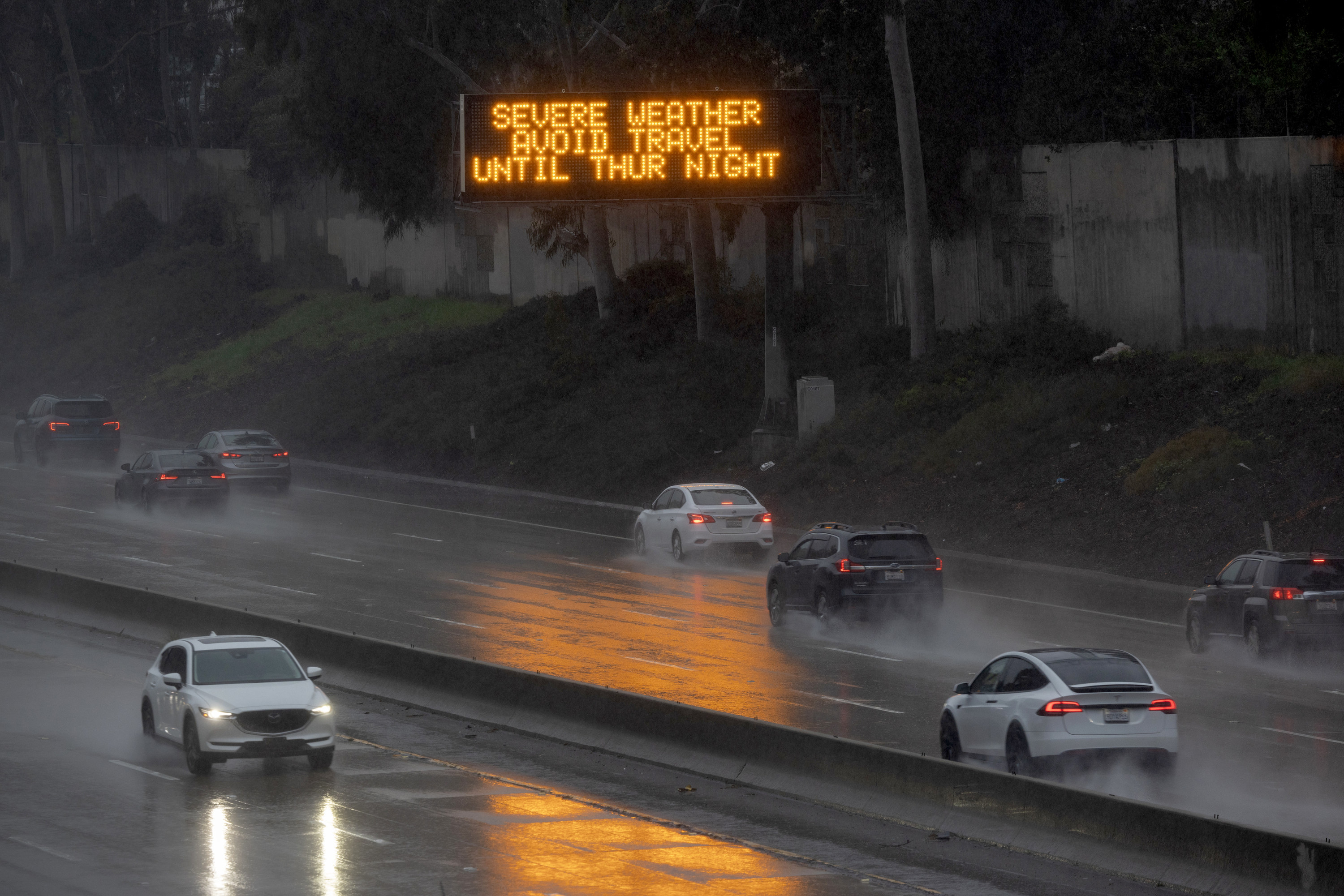 Cars on the highway with billboard reading &quot;Severe weather avoid travel until Thur night.&quot;