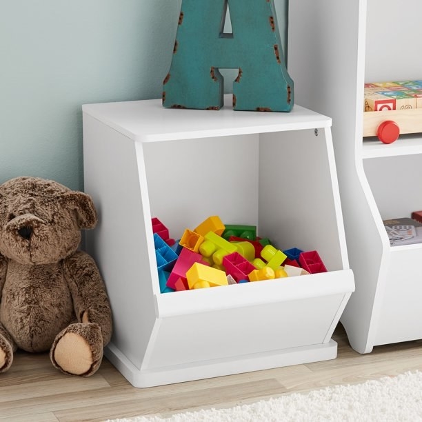 a white toy bin holding colorful buildiing blocks