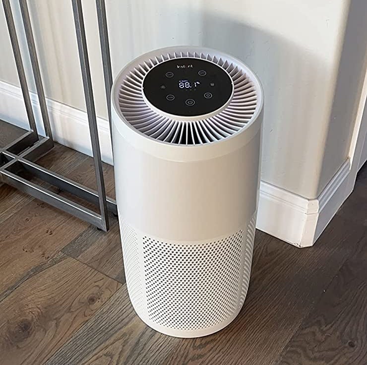 Reviewer's white air purifier on hardwood floor of room