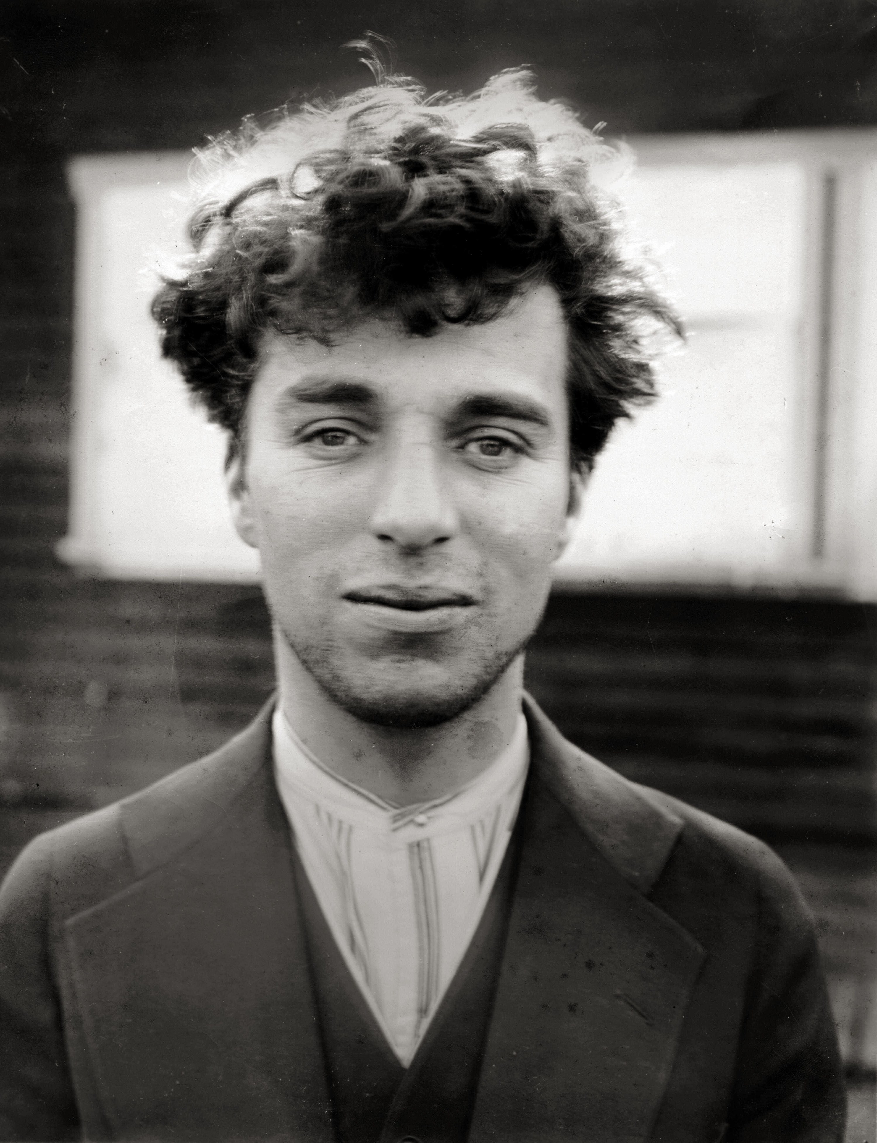 Black-and-white close-up of a man with curly hair