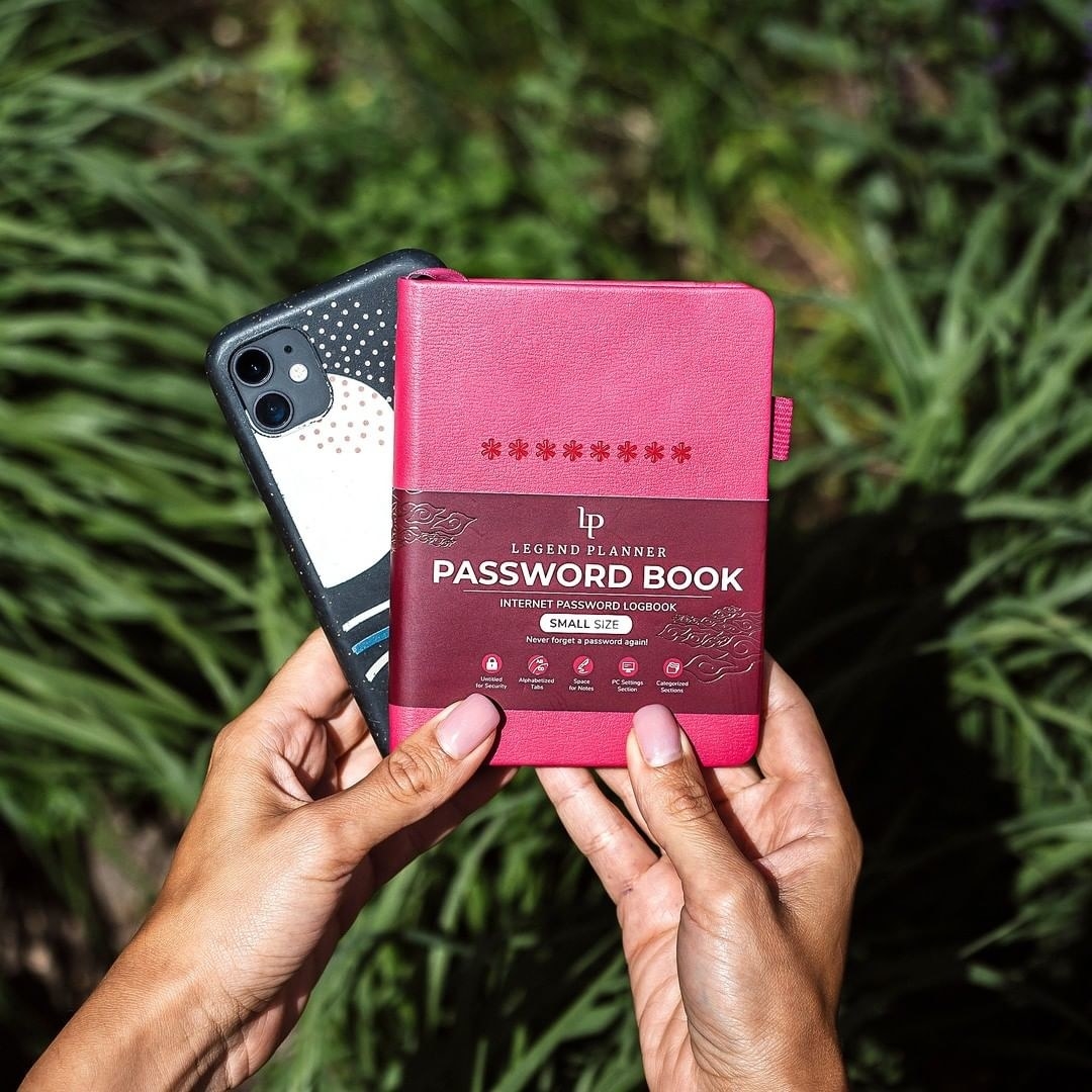 A person holding a password book and a phone