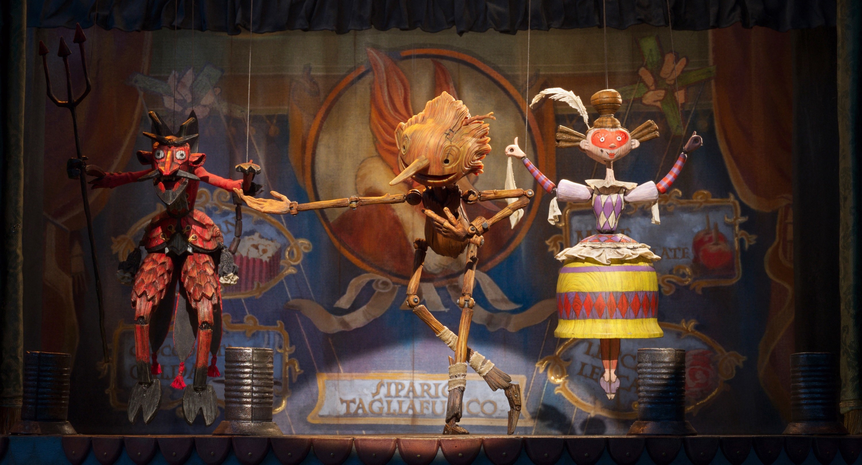 A puppet boy dances on stage with other puppets