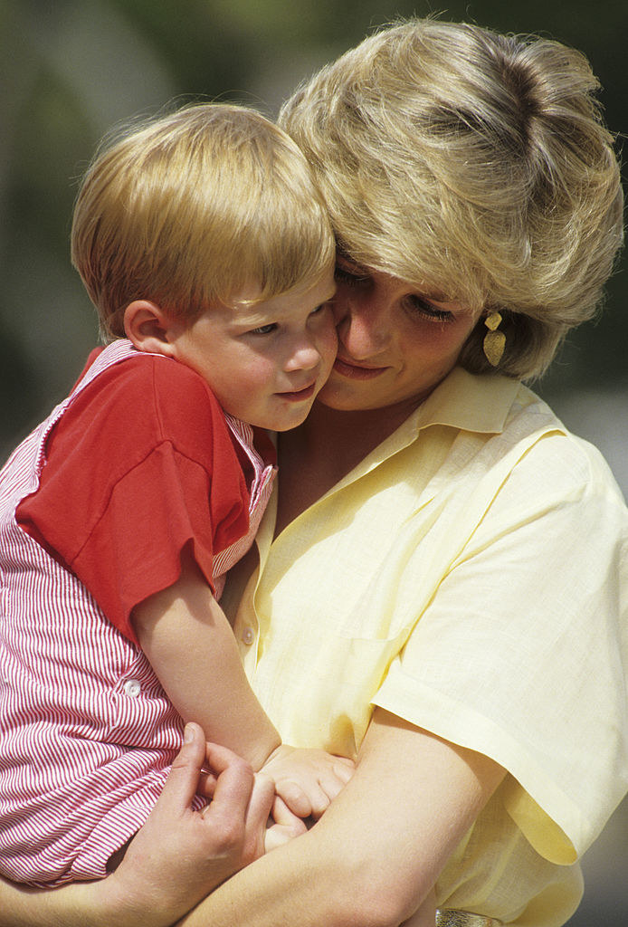 Princess Diana holding and cuddling with Harry when he was a toddler