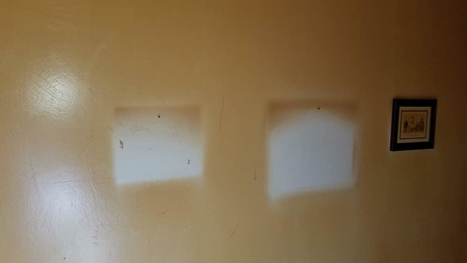 A yellowed wall except for two white patches where pictures used to be