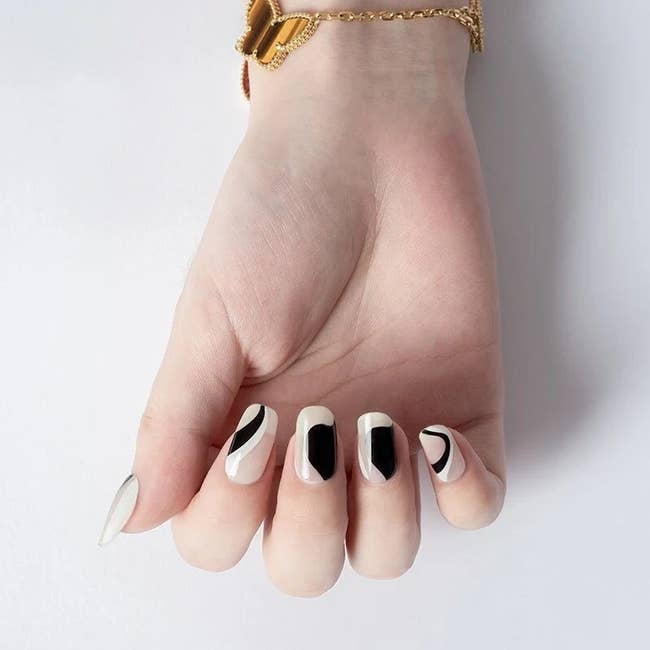 a model wearing the black and white nail wraps