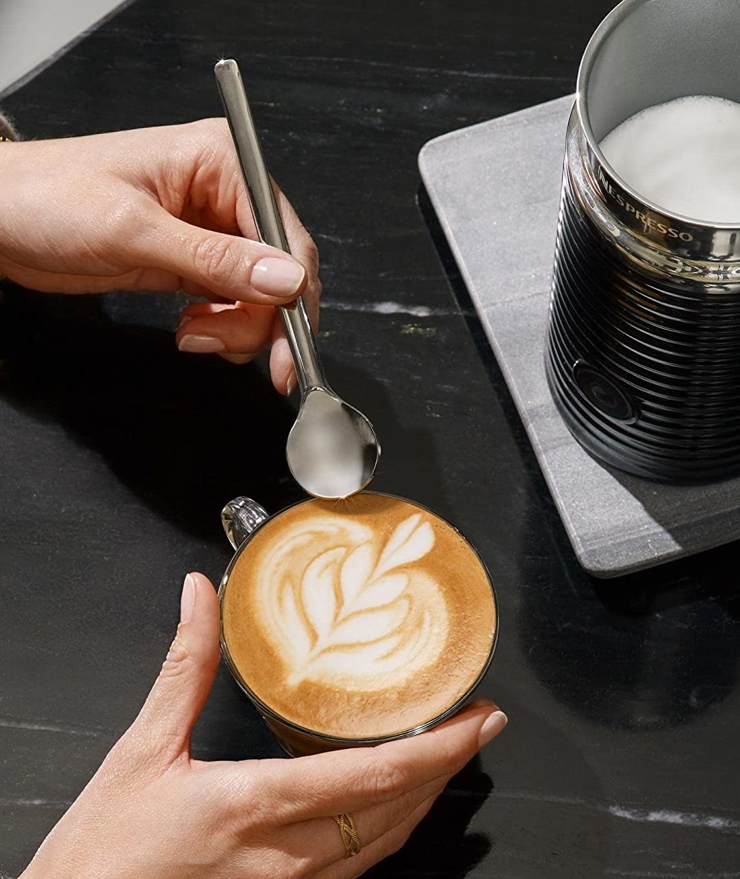 a person pouring foam into their latte